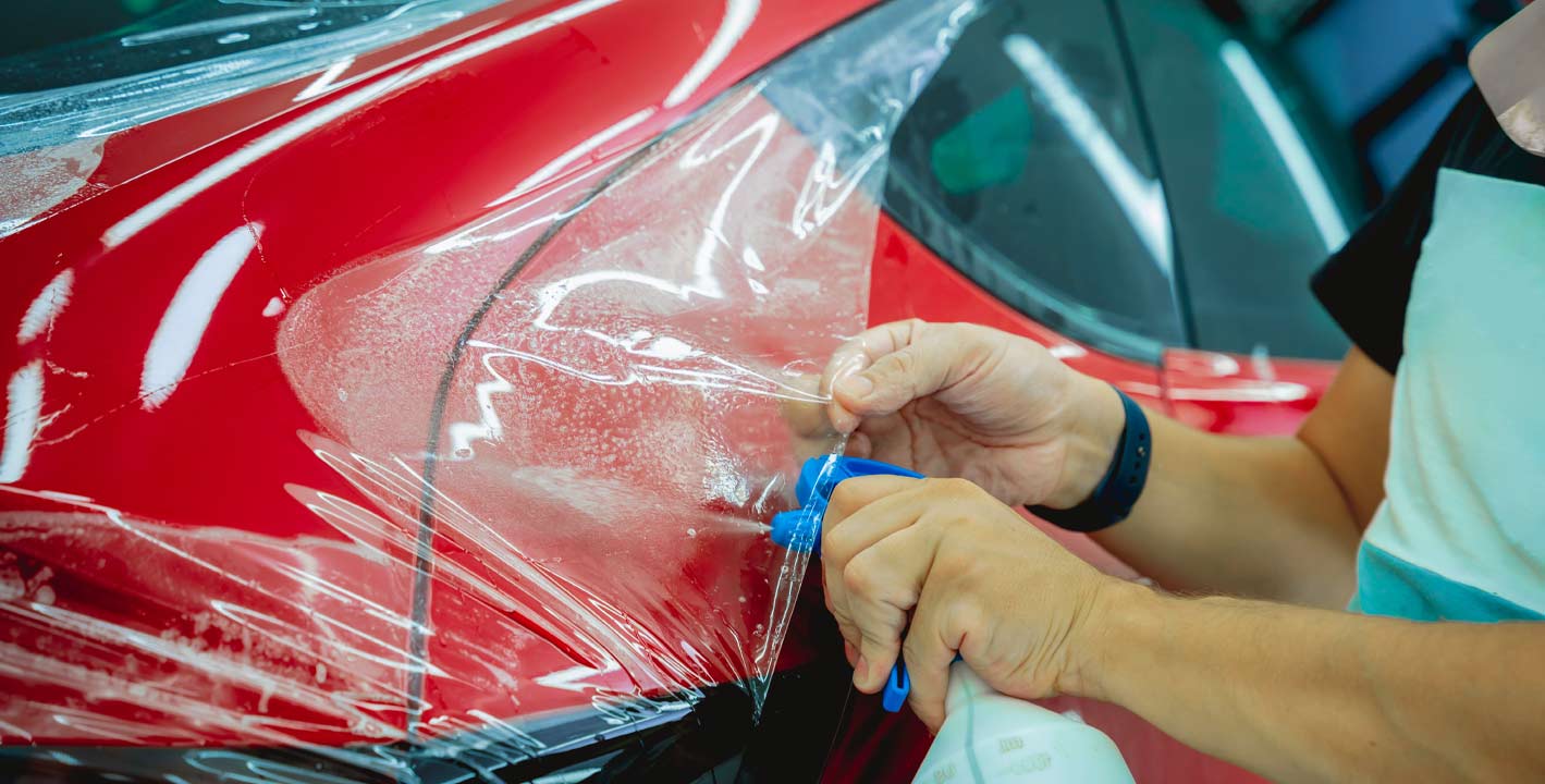 Red car having paint protection film applied for scratch and chip resistance