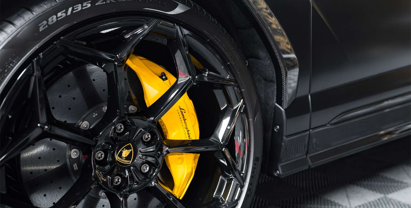 Technician applying protective treatment to a car’s alloy rim at Exclusive Car Care Abu Dhabi.